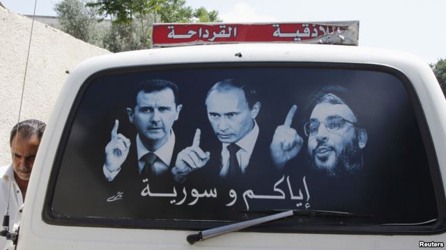 Плакат с изображением Башара Асада, Владимира Путина и главы группы Хезболла Хасана Насраллы в окне автомобиля в Латакии