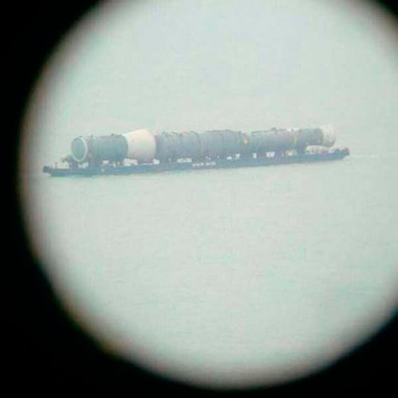 На фото представлено, что через несколько минут баржа проплывет под строящимся Крымским мостом