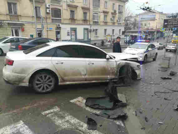 Рядом на проезжей части находится автомобиль Audi. У обеих машин видны повреждения передней части