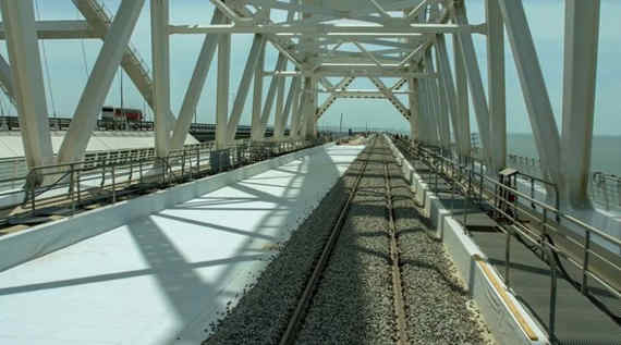 Строители завершили укладку рельсов одного из двух железнодорожных путей на Крымском мосту. Бригады укладывали рельсошпальную решетку навстречу друг другу одновременно со стороны Керчи и Тамани и встретились под сводом арки