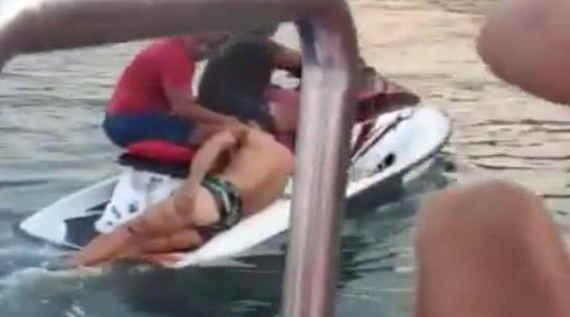 травмированного мужчину вытаскивают из воды несколько человек, находящихся на катере и на квадроцикле