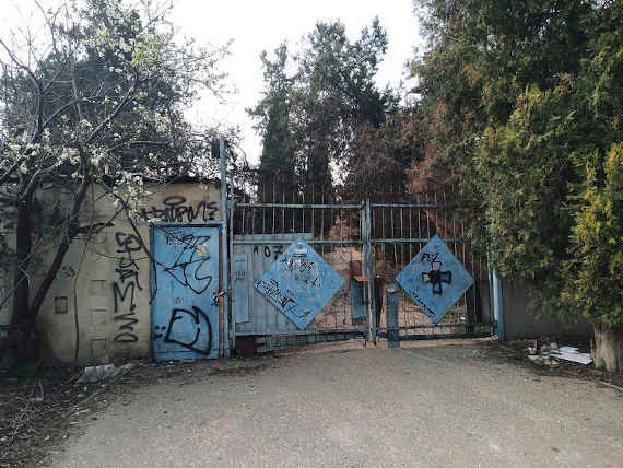 Со стороны территория бывшего завода выглядит атмосферно и несколько зловеще: забор, пусть и разрушенный в некоторых местах, сверху обмотан проволокой и «украшен» граффити и рекламой сайтов с запрещёнными веществами