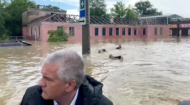 трое спасателей, которые в этот момент кролем плывут недалеко от лодки главы Крыма