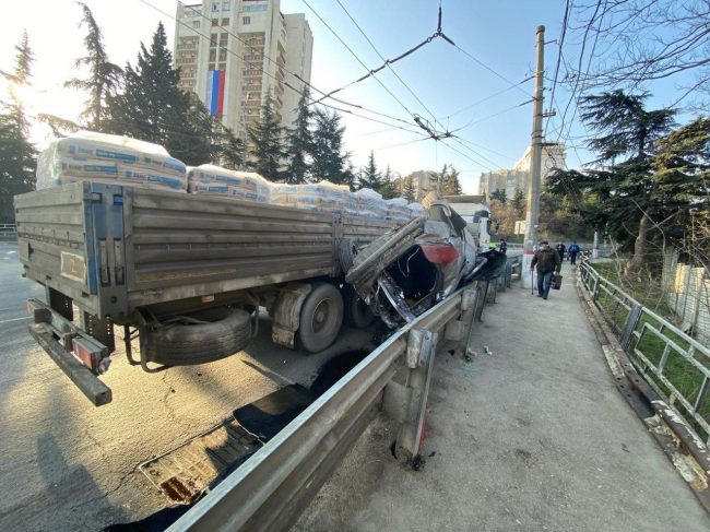 Водитель легкового автомобиля Peugeot двигался из Симферополя в сторону Ялты. И в самой Алуште, при заезде на кольцо – там дорога на Ялту уходит направо – водитель заехал под «КамАЗ»