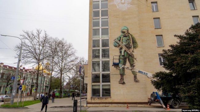 В Симферополе на южном фасаде здания главпочтамта по улице Александра Невского появилось 10 метровое изображение российского военнослужащего в полевой экипировке