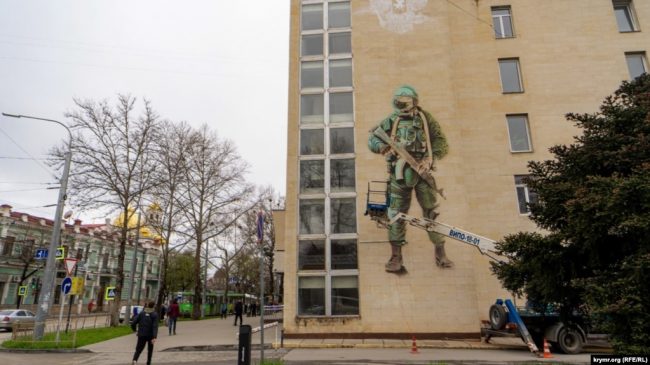 В Симферополе на южном фасаде здания главпочтамта по улице Александра Невского появилось 10 метровое изображение российского военнослужащего в полевой экипировке