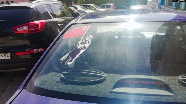 на легковых автомобилях в Симферополе появилась наклейка, изображающая «бабушку с красным флагом».