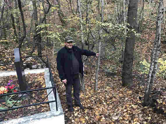 Дмитрий Тихонов показывает могилы, расположенные в метре от русла горной реки