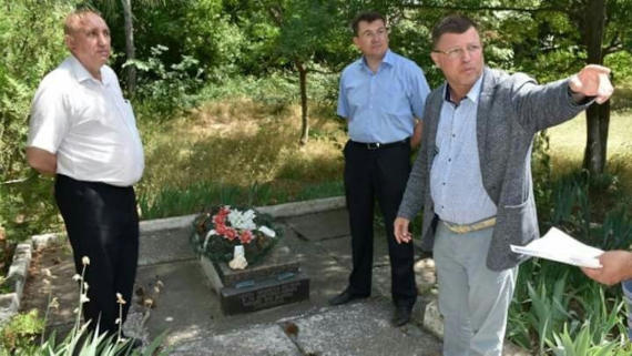 Иван Комелов демонстрирует самые дружеские намерения в отношении застройщика Андрея Григорова возле могилы советских воинов, которая мешает застройке