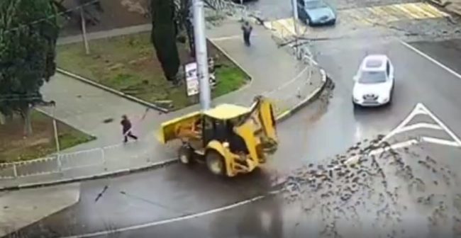 трактор выезжает с дороги на тротуар и сносит дорожные ограждени